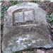 Photo of broken and buried headstone - staff unable to read deceased's name