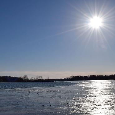Sparkling lake under a blue sky and bright sun