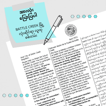 Gray background with blue sticky note promoting city community survey in Burmese text
