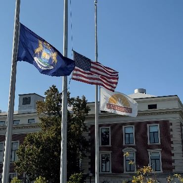 A photo of the U.S., State of Michigan, and City of Battle Creek flags at half-staff.