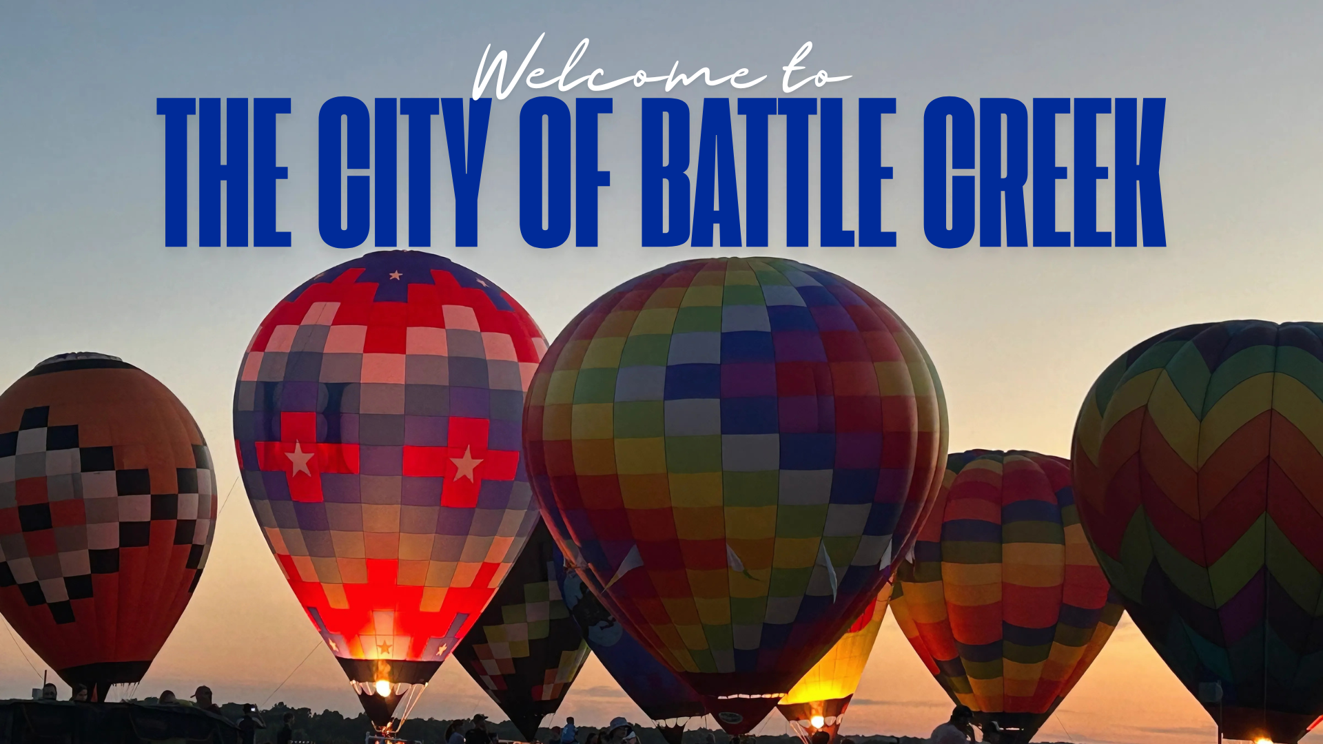 Balloons landing at sunset with the words Welcome to Battle Creek above