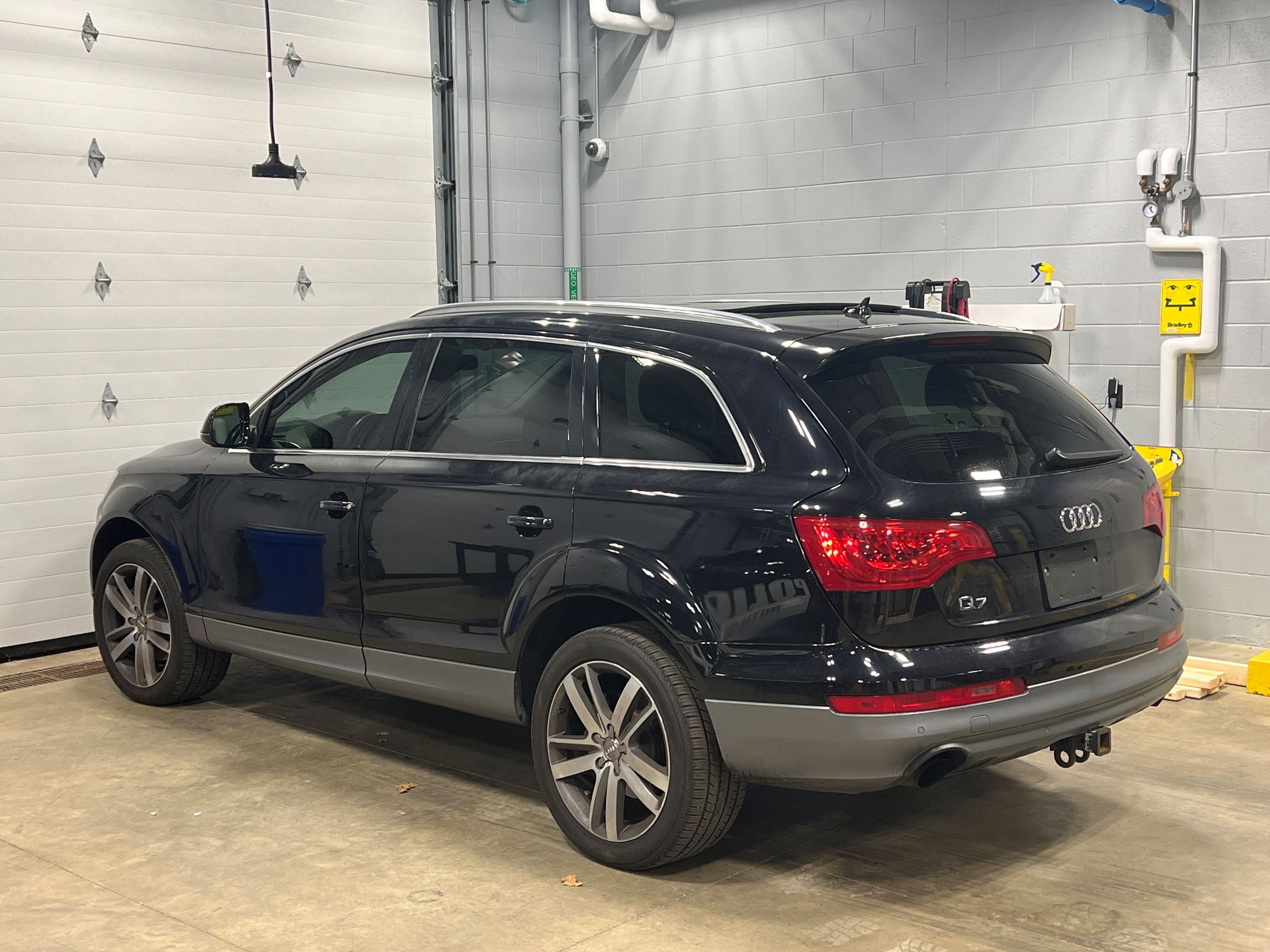 Black Audi Q7 from the back, sitting in a garage