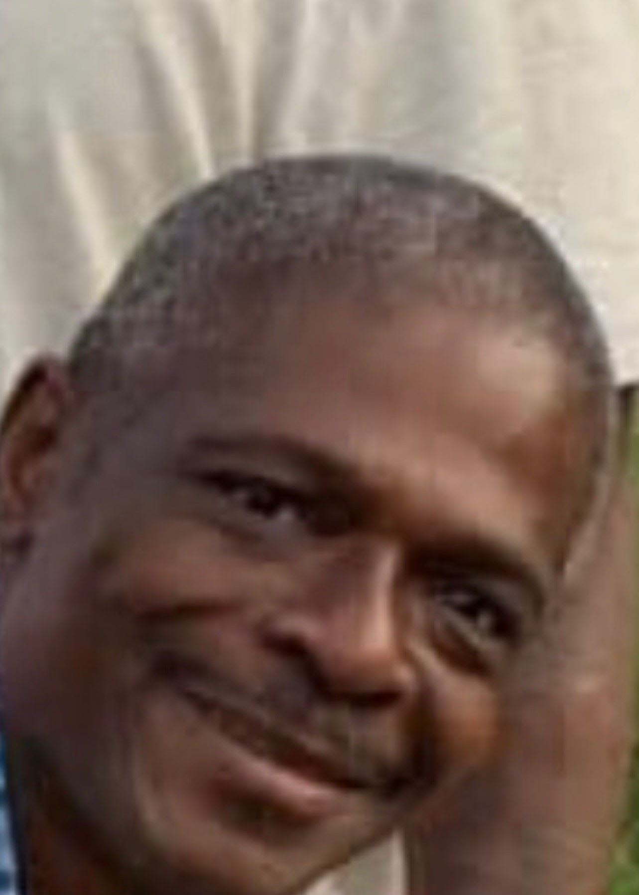 Black man with mustache smiling.